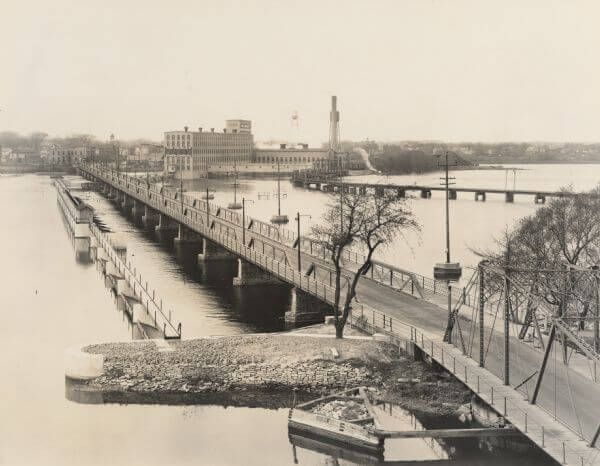 An old grayscale photograph of De Pere, Wisconsin. De Pere, Wisconsin is a location served by Rosenow Customs.