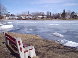 A bench sitting by a frozen pond in Hortonville, Wisconsin. Hortonville, Wisconsin is a location served by Rosenow Customs.